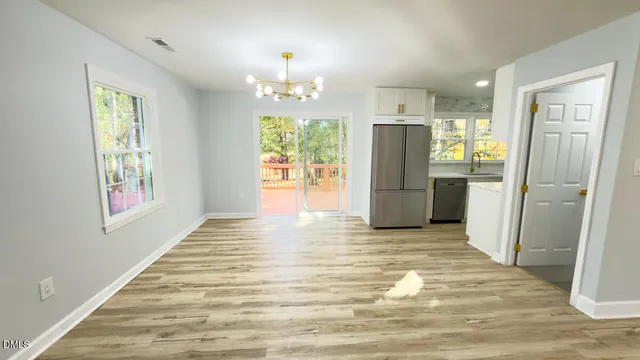 a view of a kitchen with a refrigerator a ceiling fan and wooden floor
