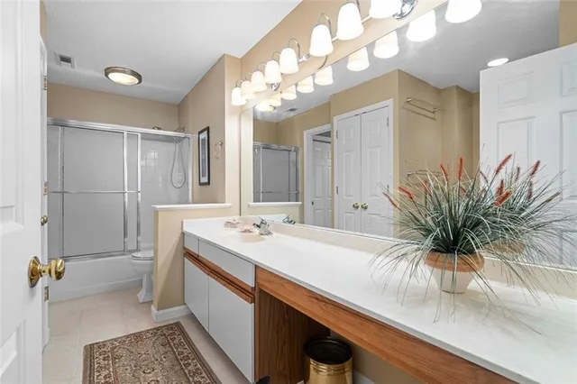 a bathroom with a granite countertop sink a large mirror and a shower