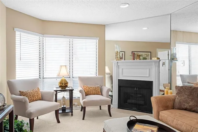 a living room with furniture a large window and a fireplace