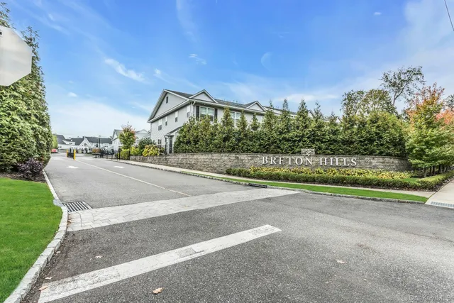 a view of a house with a yard and a large parking space