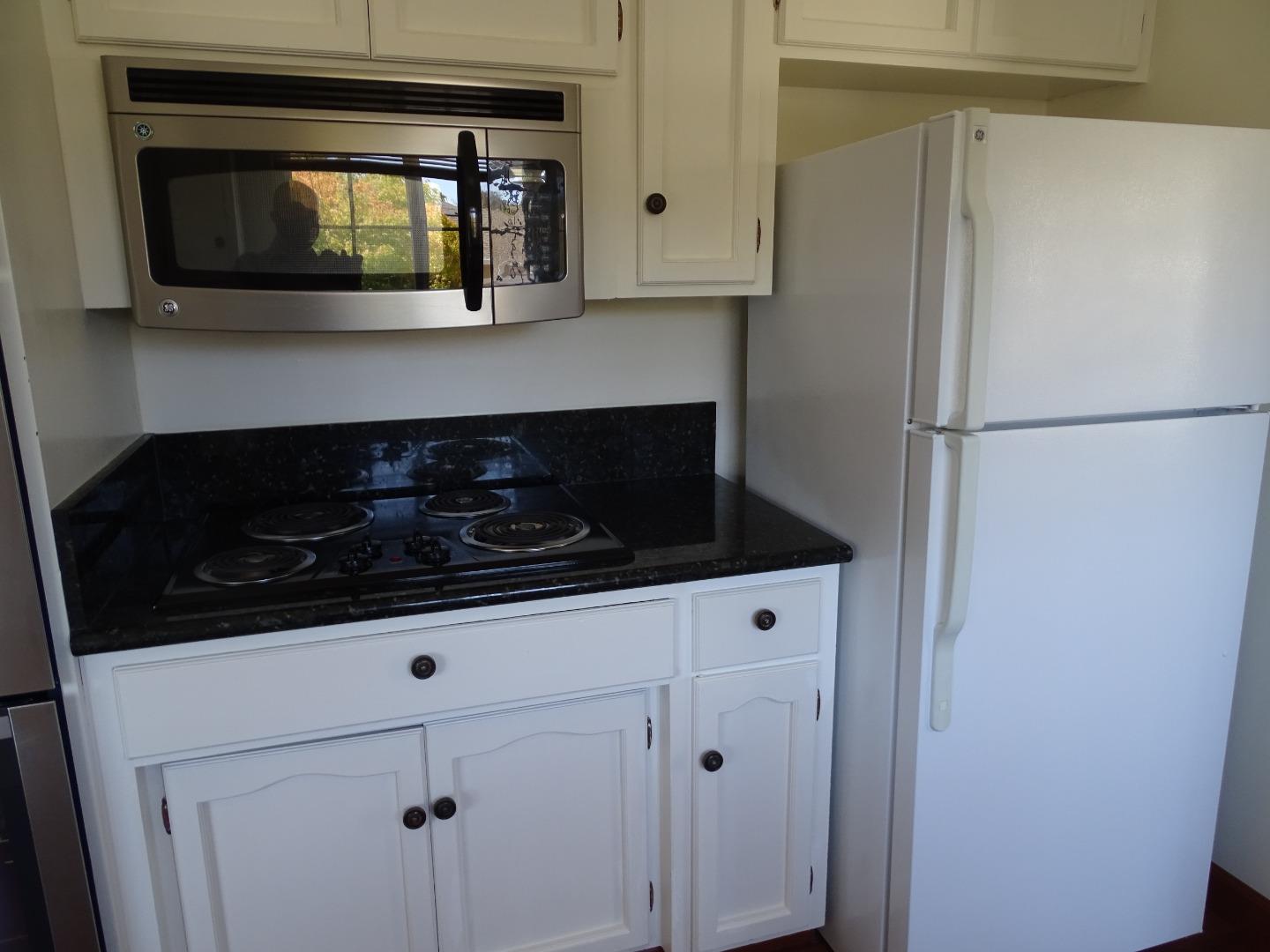 3345 Glendora Drive San Mateo, CA 94403 - Photo 4 of 19 a kitchen with white cabinets and black appliances