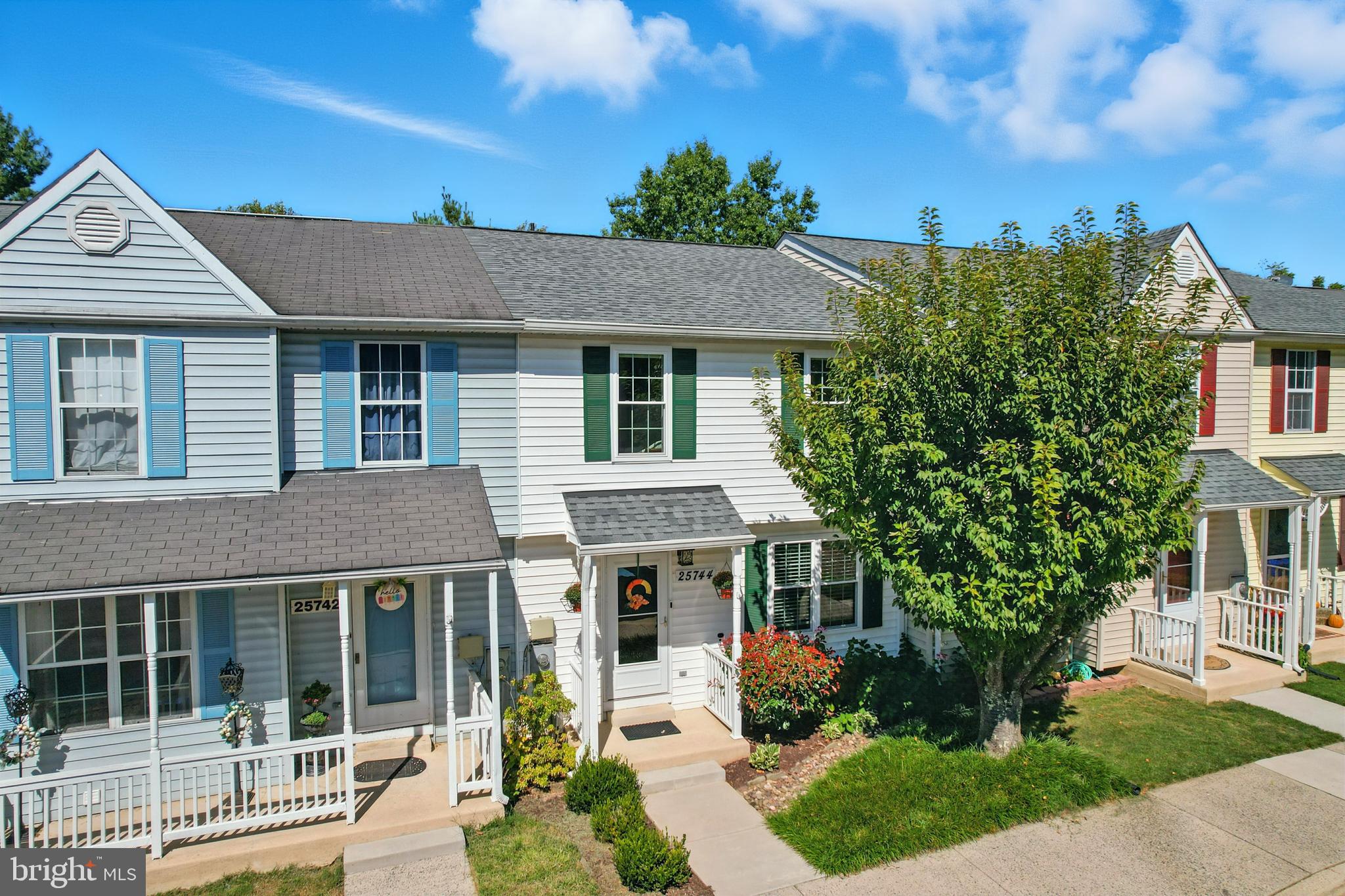 25744 Woodfield Road Damascus, MD 20872 - Photo 4 of 43 Charming townhomes under a bright blue sky.