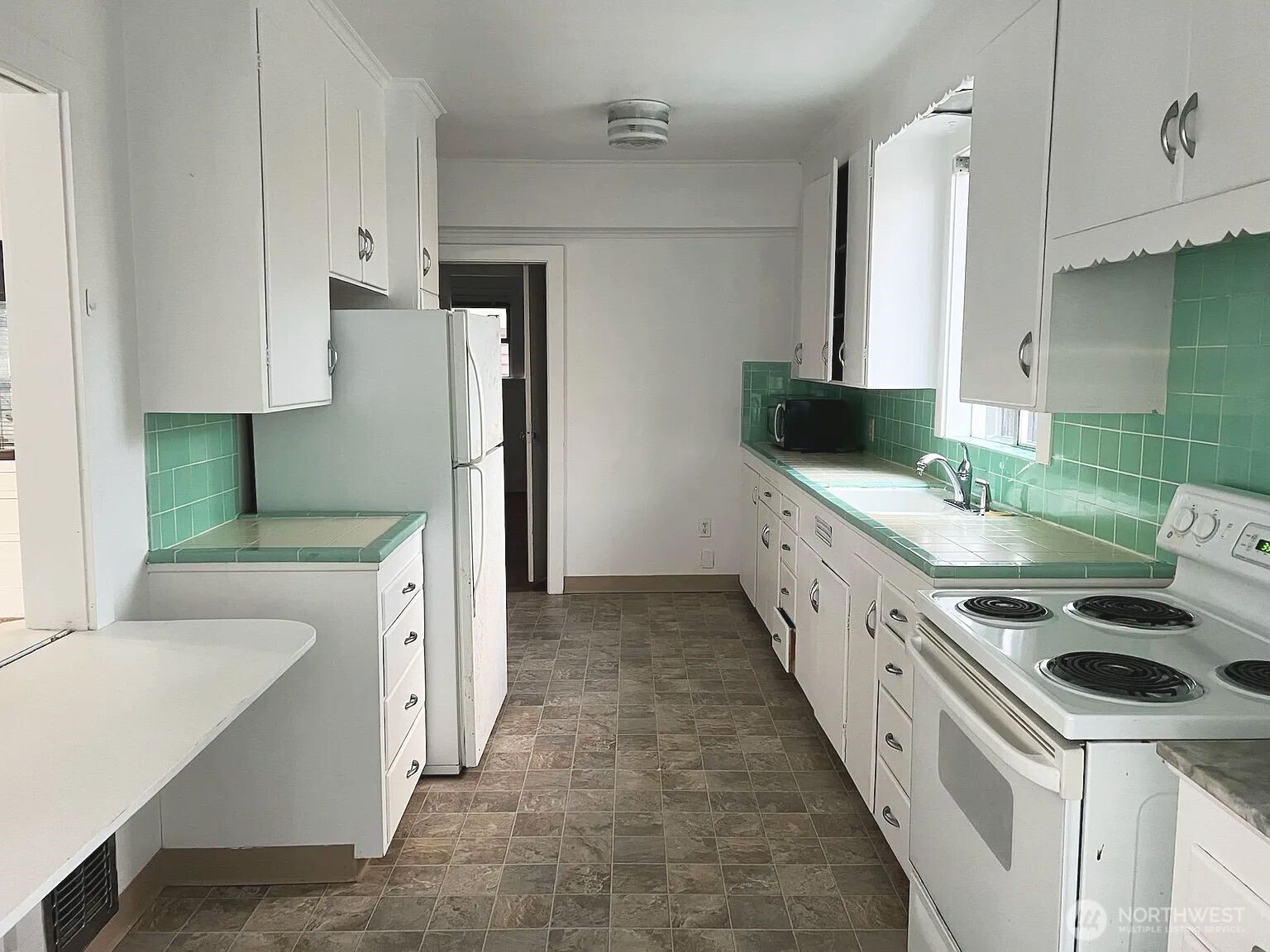 4002 2nd Avenue Northeast Seattle, WA 98105 - Photo 15 of 16 a kitchen with granite countertop a sink and a stove top oven