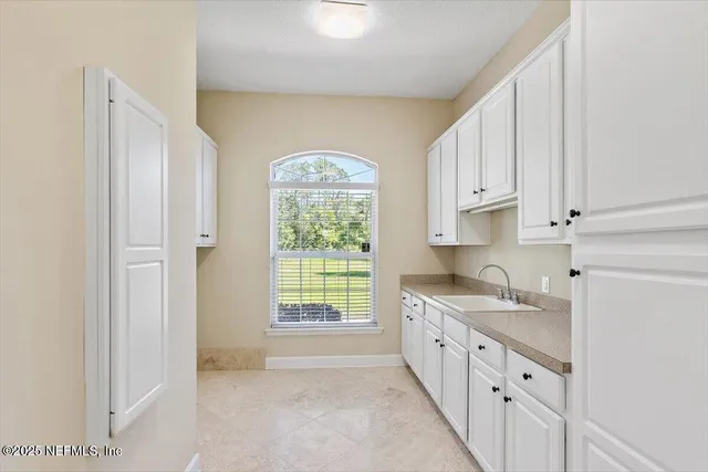 a kitchen with a sink a window and cabinets