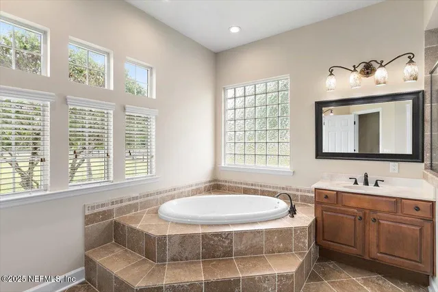a bathroom with a tub sink and mirror