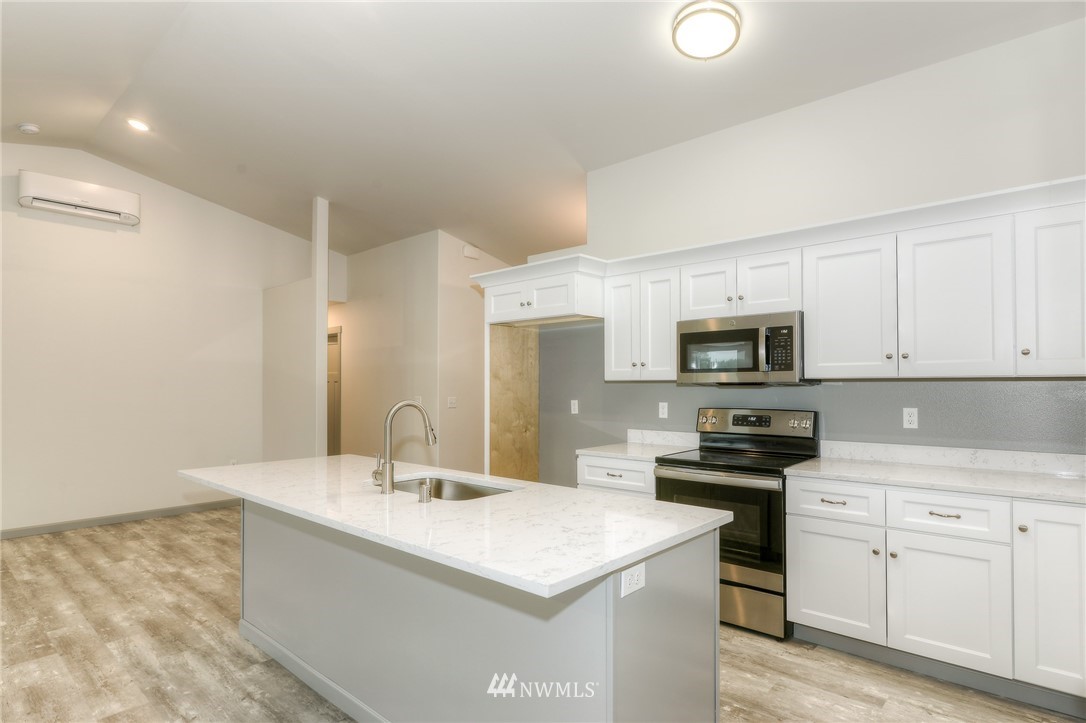 18430 Guava Street Southwest Rochester, WA 98579 - Photo 13 of 36 a kitchen with stainless steel appliances a sink a stove a microwave and cabinets