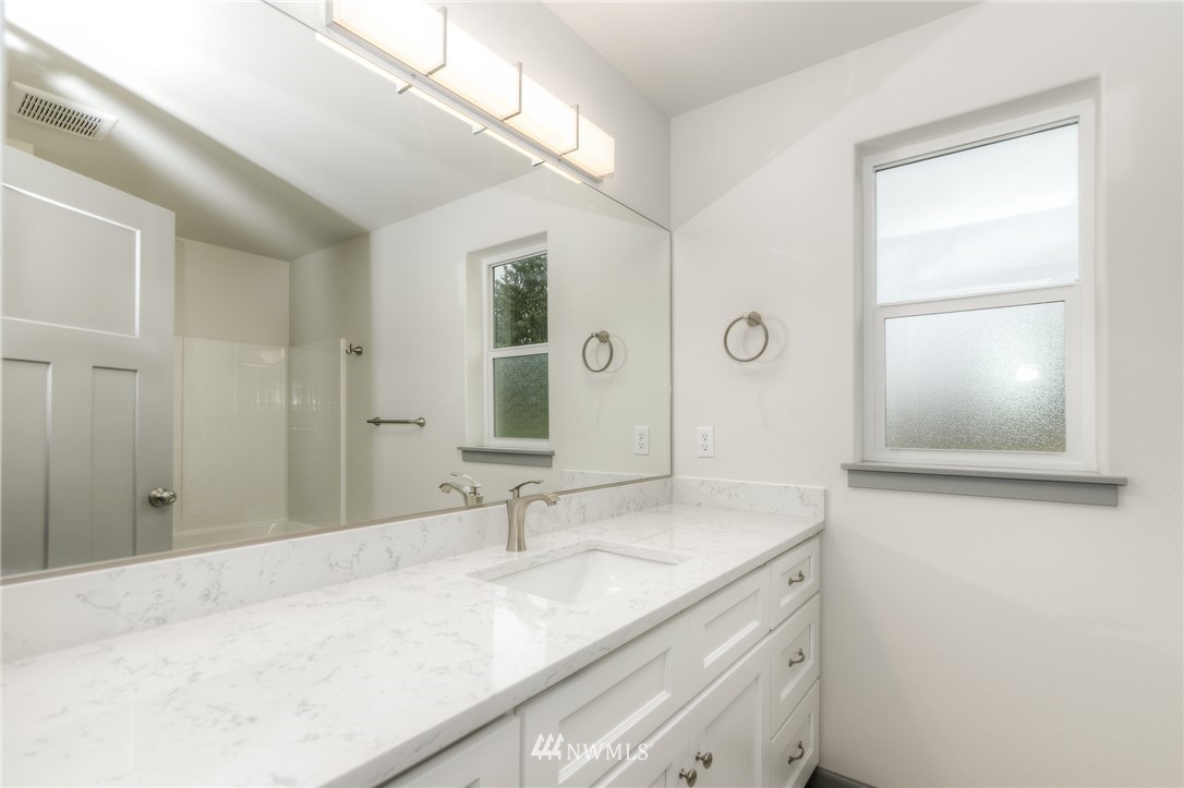 18430 Guava Street Southwest Rochester, WA 98579 - Photo 18 of 36 a bathroom with a granite countertop sink and a mirror