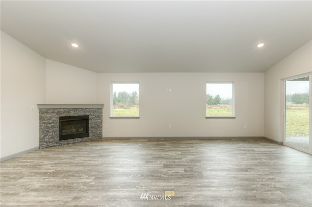 18430 Guava Street Southwest Rochester, WA 98579 - Photo 9 of 36 an empty room with windows and fireplace