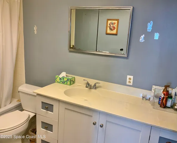 a bathroom with a sink vanity mirror and toilet