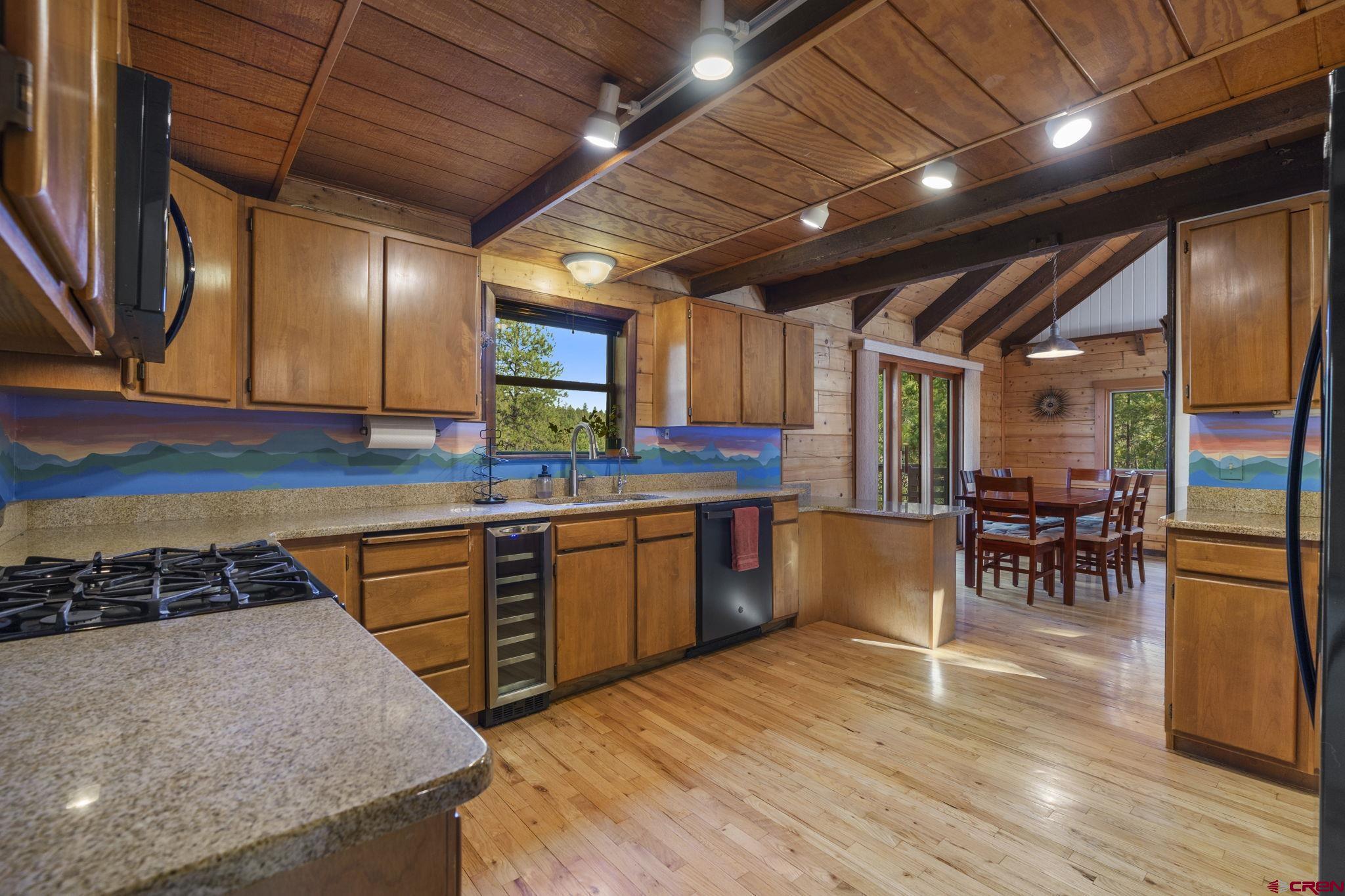 1310 Meadow Road Durango, CO 81303 - Photo 15 of 45 a kitchen with stainless steel appliances granite countertop wooden floors a stove and a sink