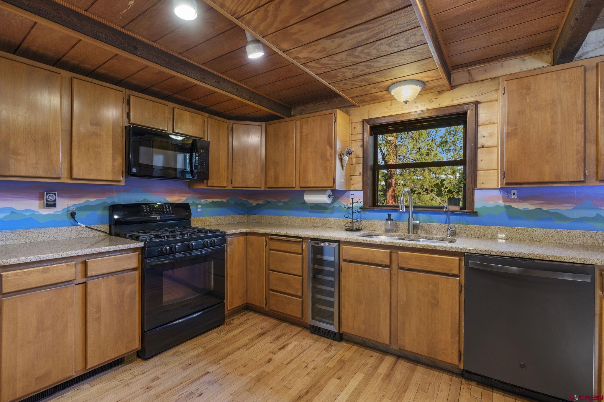 1310 Meadow Road Durango, CO 81303 - Photo 16 of 45 a kitchen with stainless steel appliances granite countertop wooden cabinets sink and stove top oven