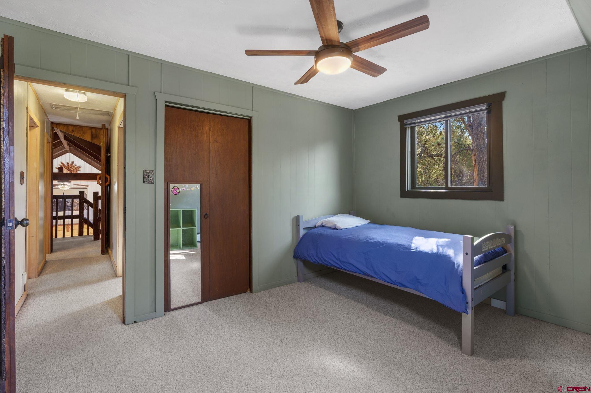 1310 Meadow Road Durango, CO 81303 - Photo 28 of 45 a bedroom with a bed and a chandelier