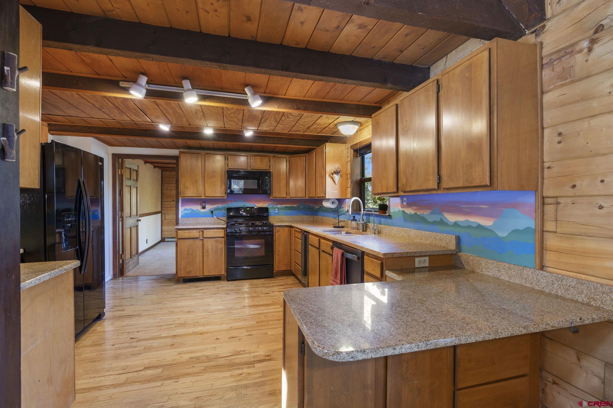 1310 Meadow Road Durango, CO 81303 - Photo 4 of 45 a kitchen with stainless steel appliances granite countertop a sink a stove and a wooden floors