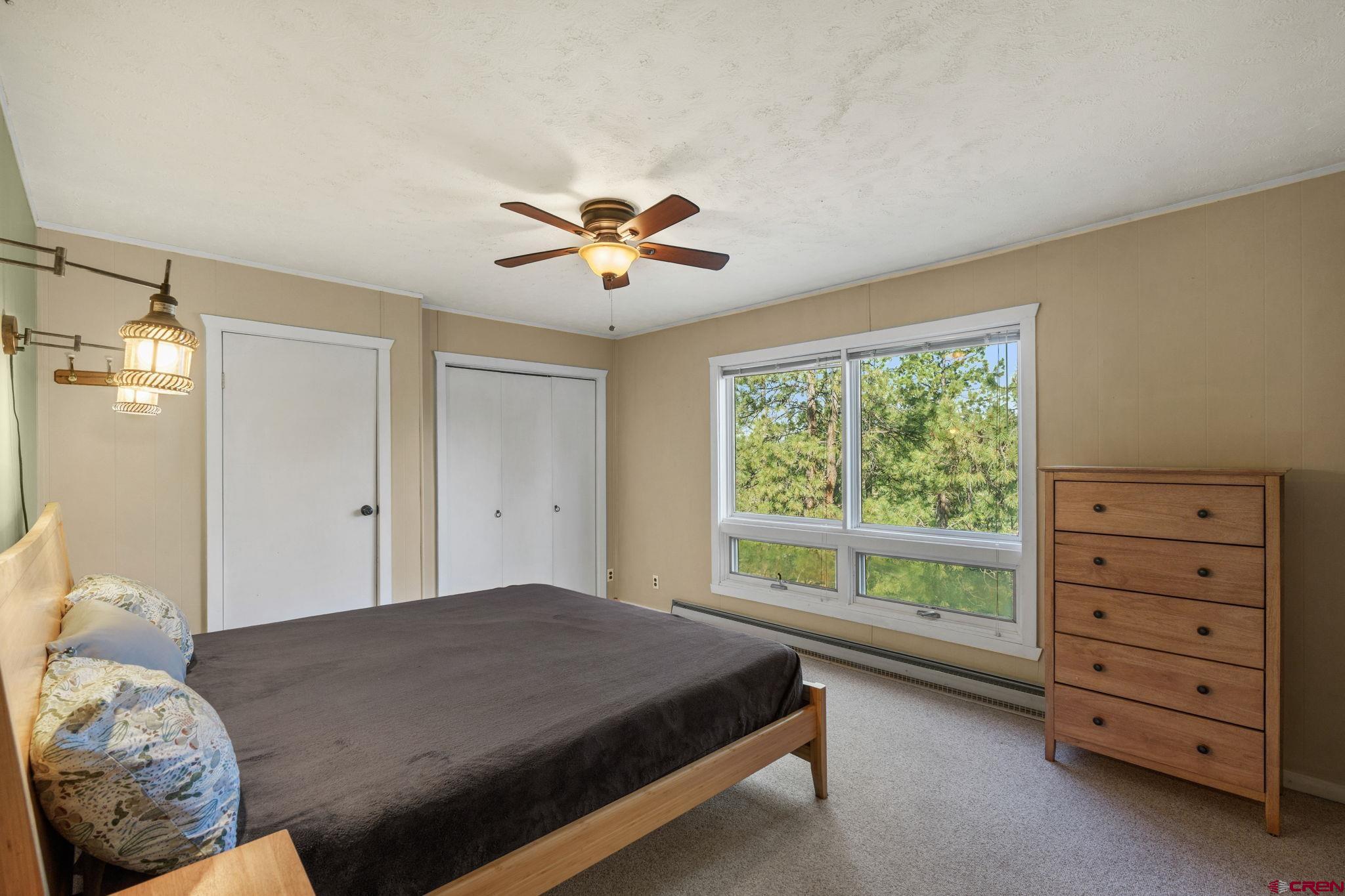 1310 Meadow Road Durango, CO 81303 - Photo 6 of 45 a spacious bedroom with a bed and a chandelier