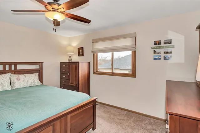 a bedroom with a bed and a ceiling fan