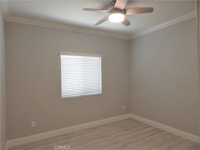 an empty room with a window and a fan