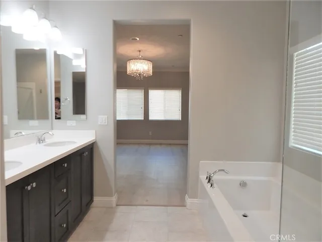 a bathroom with a double vanity sink mirror and bathtub