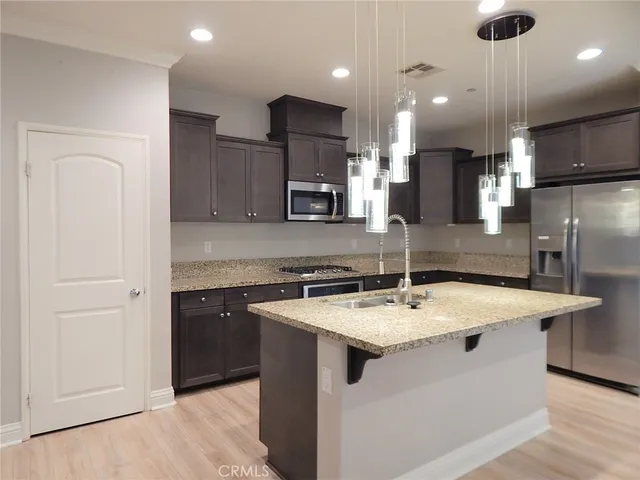a kitchen with a sink a counter top space and stainless steel appliances