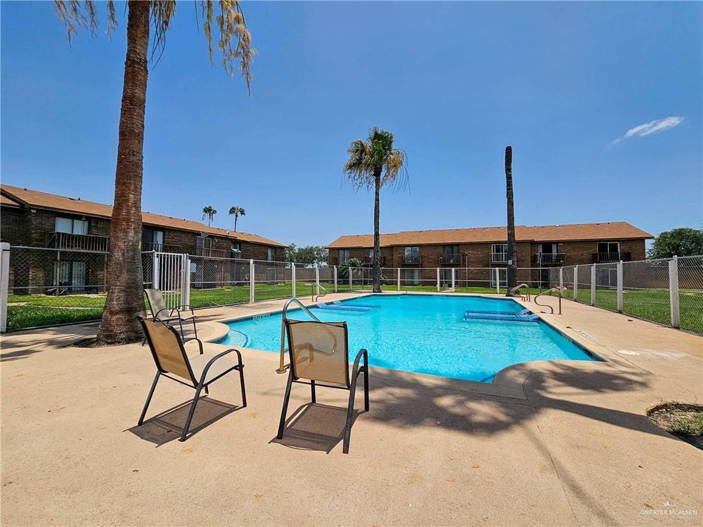 2201 South Jackson Road, Unit 2I Pharr, TX 78577 - Photo 21 of 23 Resort-style pool area featuring a rectangular swimming pool, concrete pool deck, and surrounding chain-link fencing