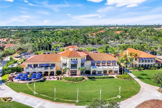 a view of a white house with a big yard and potted plants