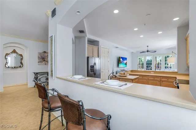 a dining hall with stainless steel appliances granite countertop a table and chairs a refrigerator with wooden floor