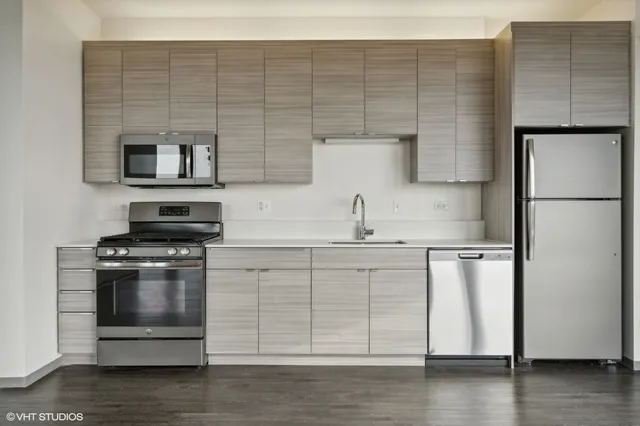 a kitchen with a refrigerator stove and wooden floor