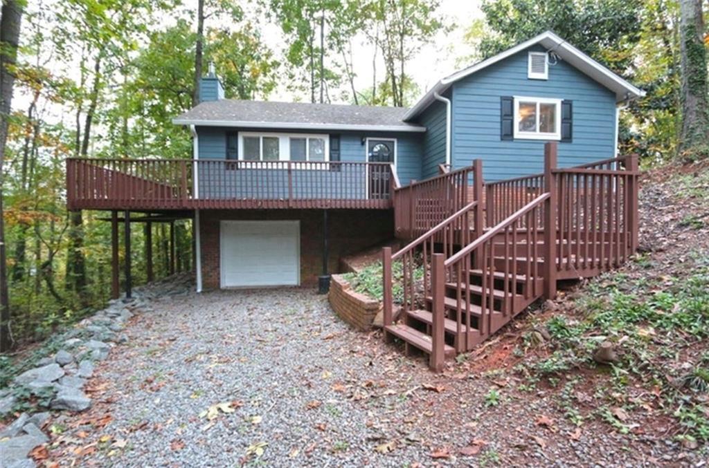 a view of house with a yard and deck area