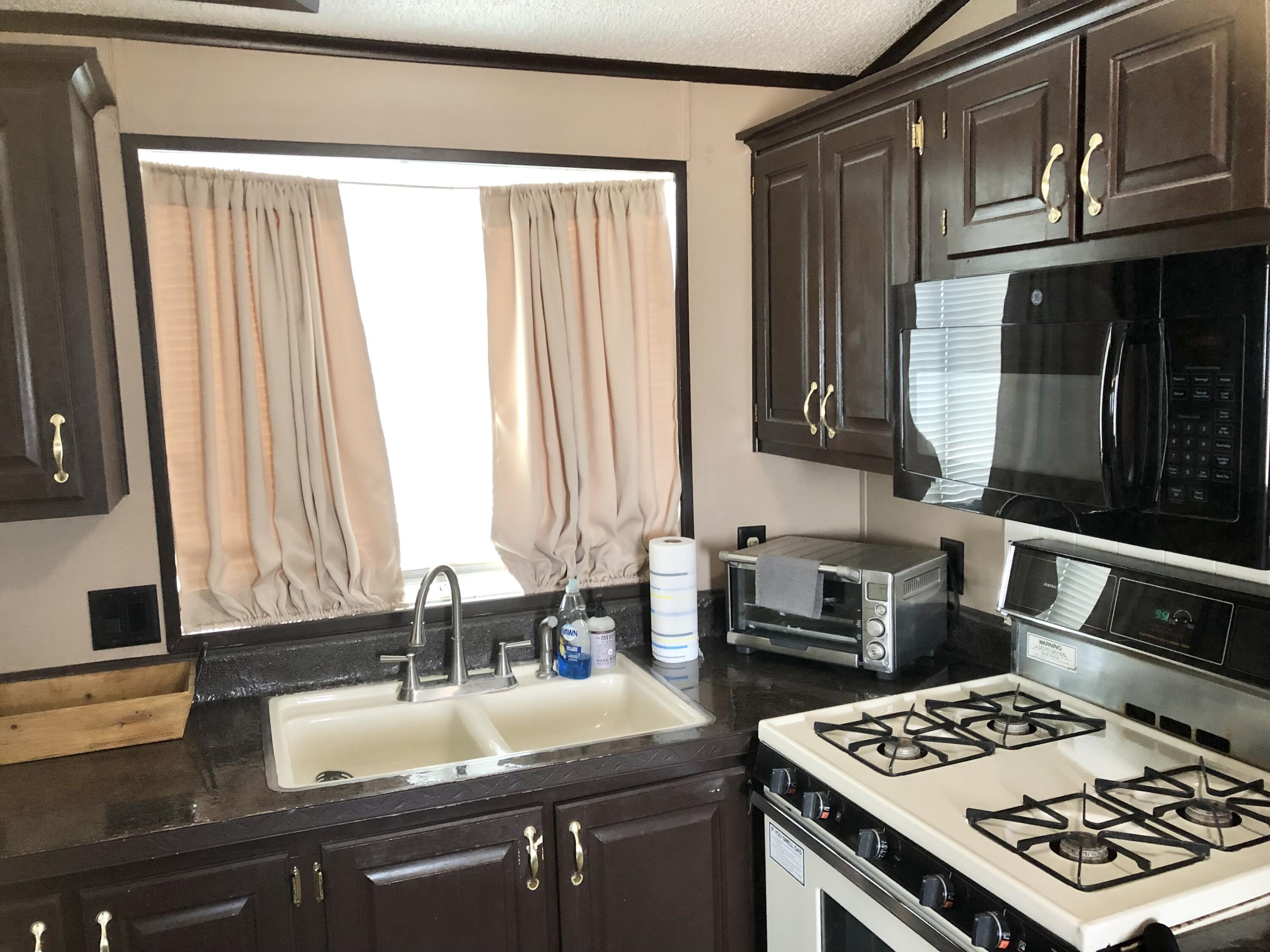 74711 Dillon Road Desert Hot Springs, CA 92241 - Photo 18 of 48 a kitchen with a sink stove and cabinets