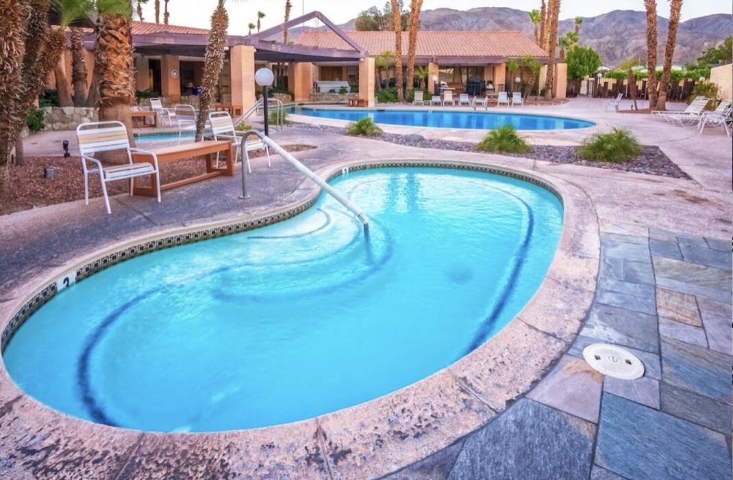 74711 Dillon Road Desert Hot Springs, CA 92241 - Photo 25 of 48 a view of a swimming pool with a lounge chairs