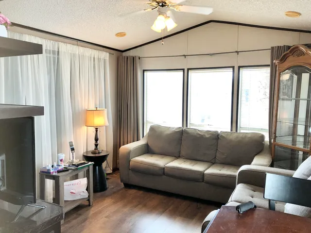 a kitchen with stainless steel appliances a dining table chairs refrigerator and sink