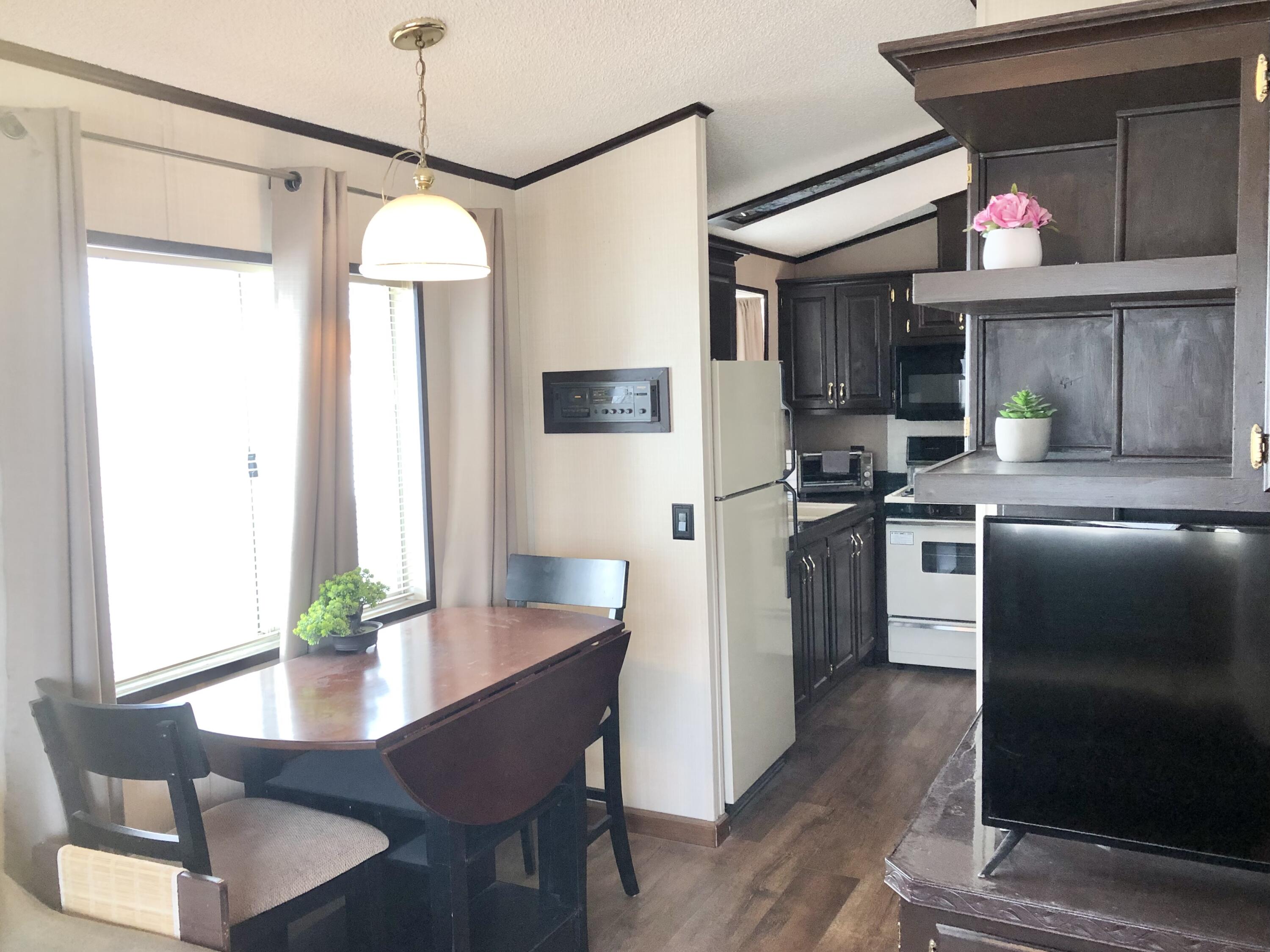 74711 Dillon Road Desert Hot Springs, CA 92241 - Photo 9 of 48 a kitchen with stainless steel appliances a dining table chairs refrigerator and sink