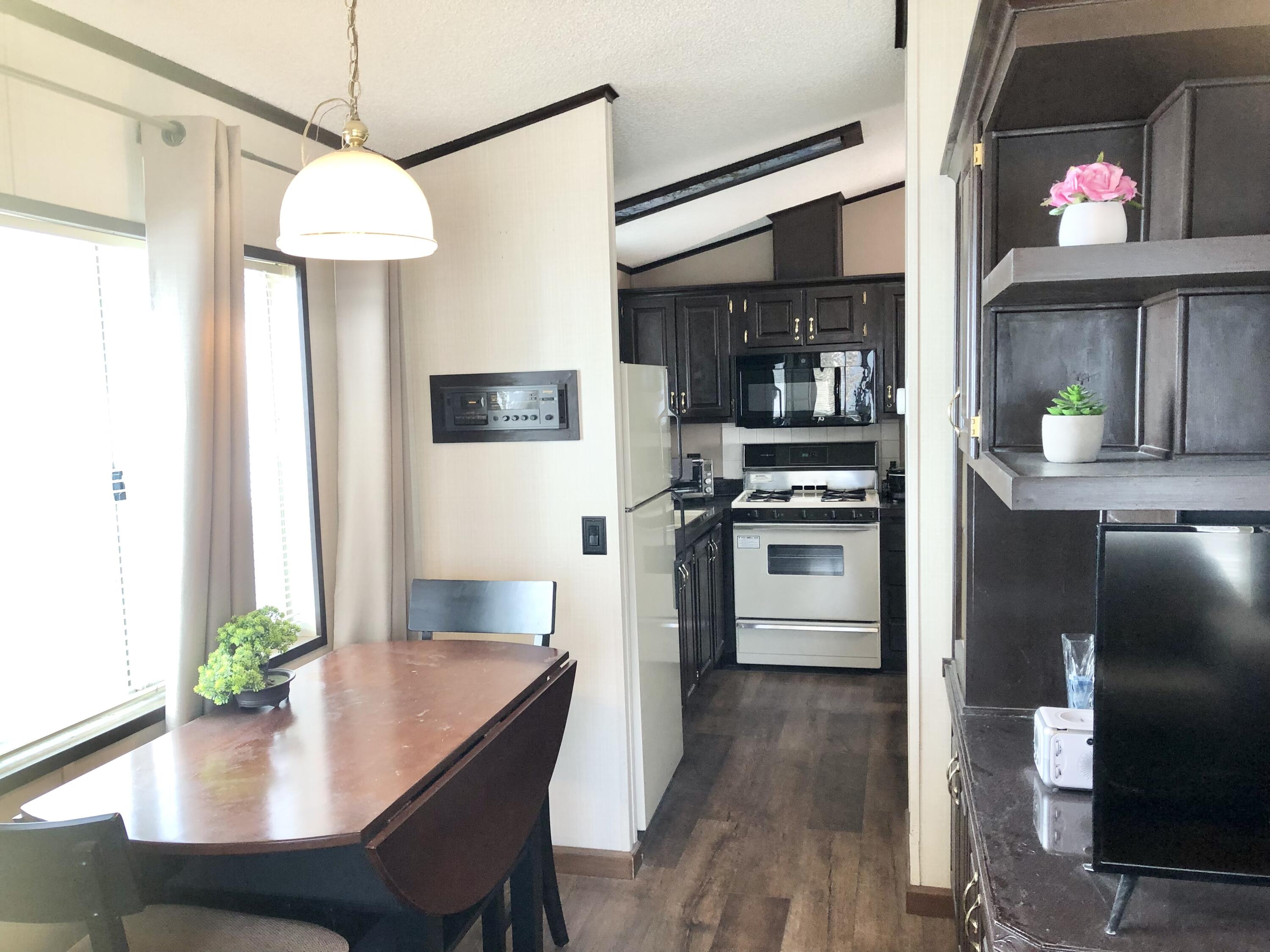 74711 Dillon Road Desert Hot Springs, CA 92241 - Photo 10 of 48 a kitchen with stainless steel appliances a dining table chairs and a refrigerator