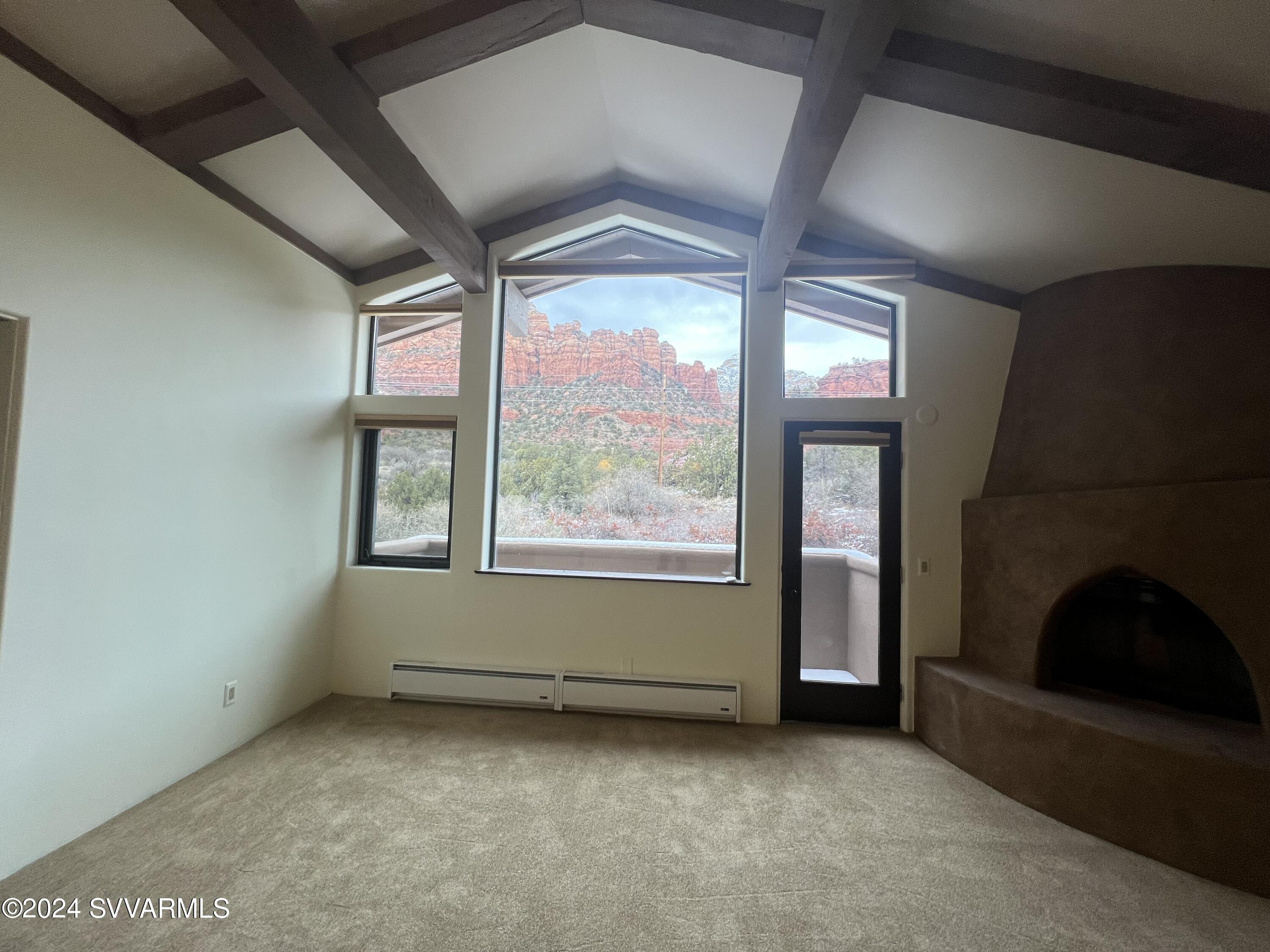 985 Rodeo Road Sedona, AZ 86336 - Photo 6 of 12 a view of an empty room with a fireplace and a window