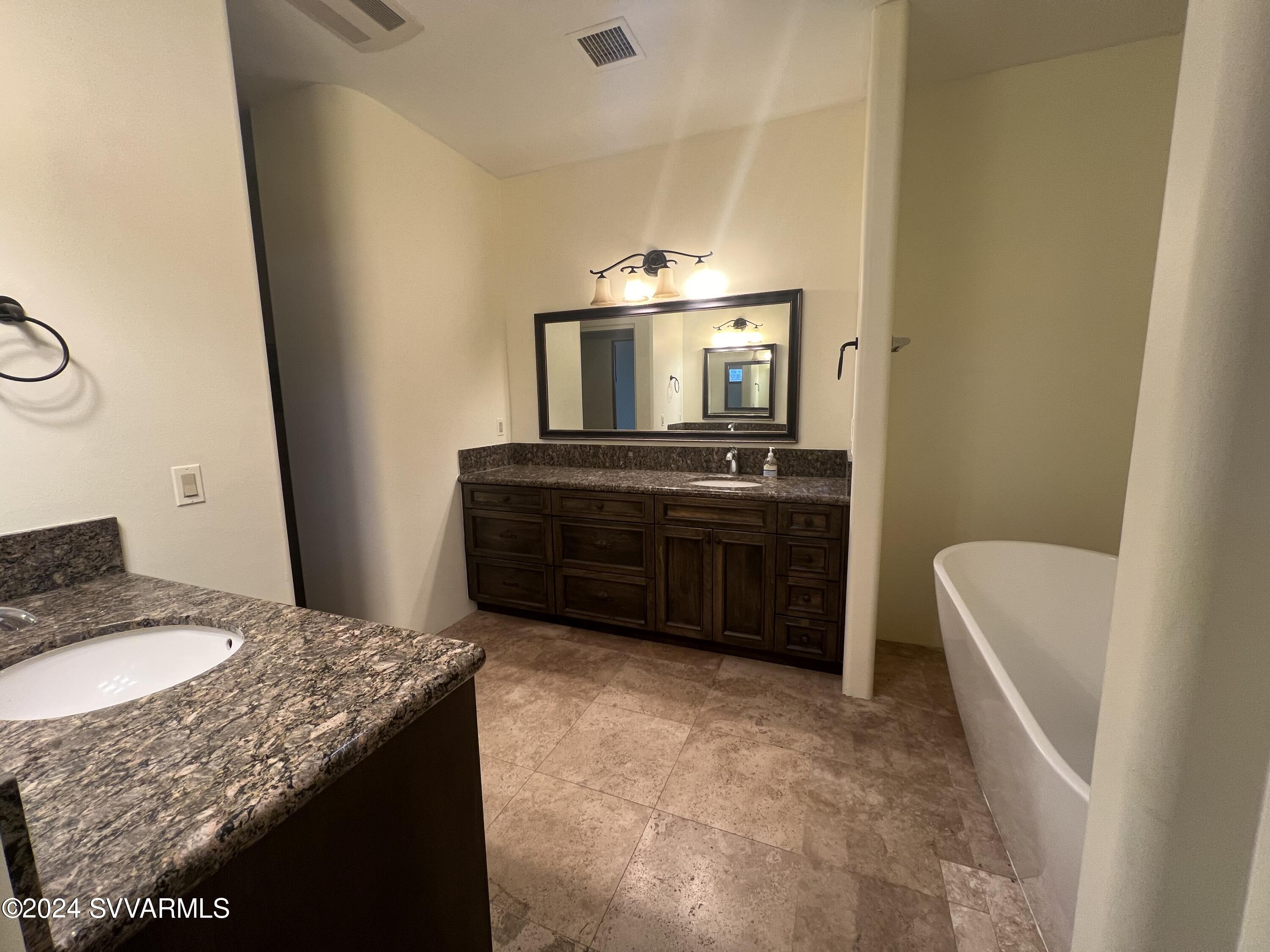 985 Rodeo Road Sedona, AZ 86336 - Photo 8 of 12 a bathroom with a granite countertop sink a mirror and a bathtub