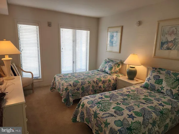 a bedroom with two beds and painting on the wall