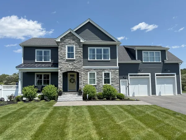 a front view of a house with a yard and garage