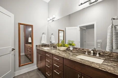 a bathroom with a granite countertop sink double and mirror