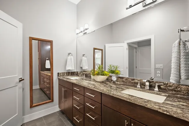a bathroom with a granite countertop sink double and mirror