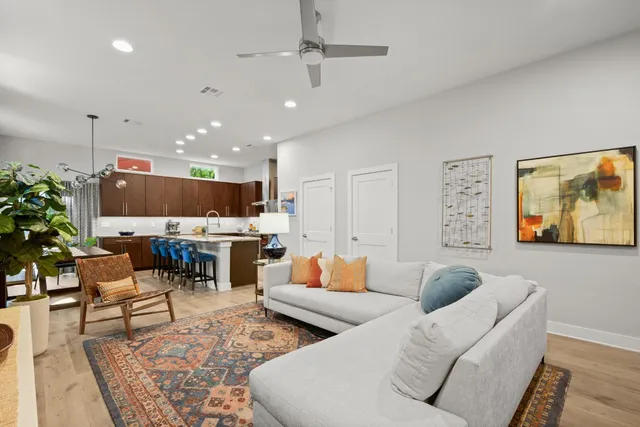 a living room with furniture kitchen view and a large window