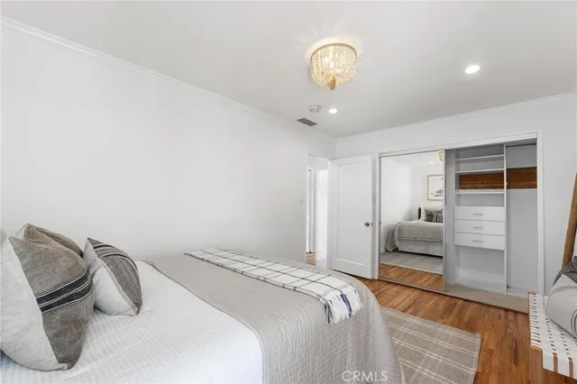 a bedroom with a bed and a view of living room