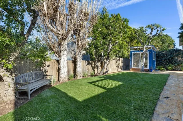 a front view of a house with a garden and trees