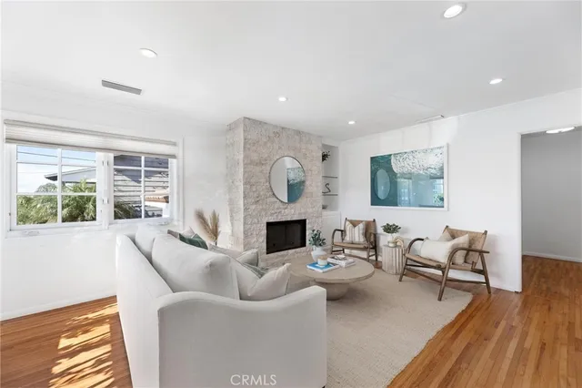 a living room with furniture a fireplace a large window and a flat screen tv