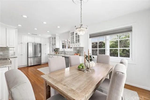 a kitchen with a dining table chairs and refrigerator