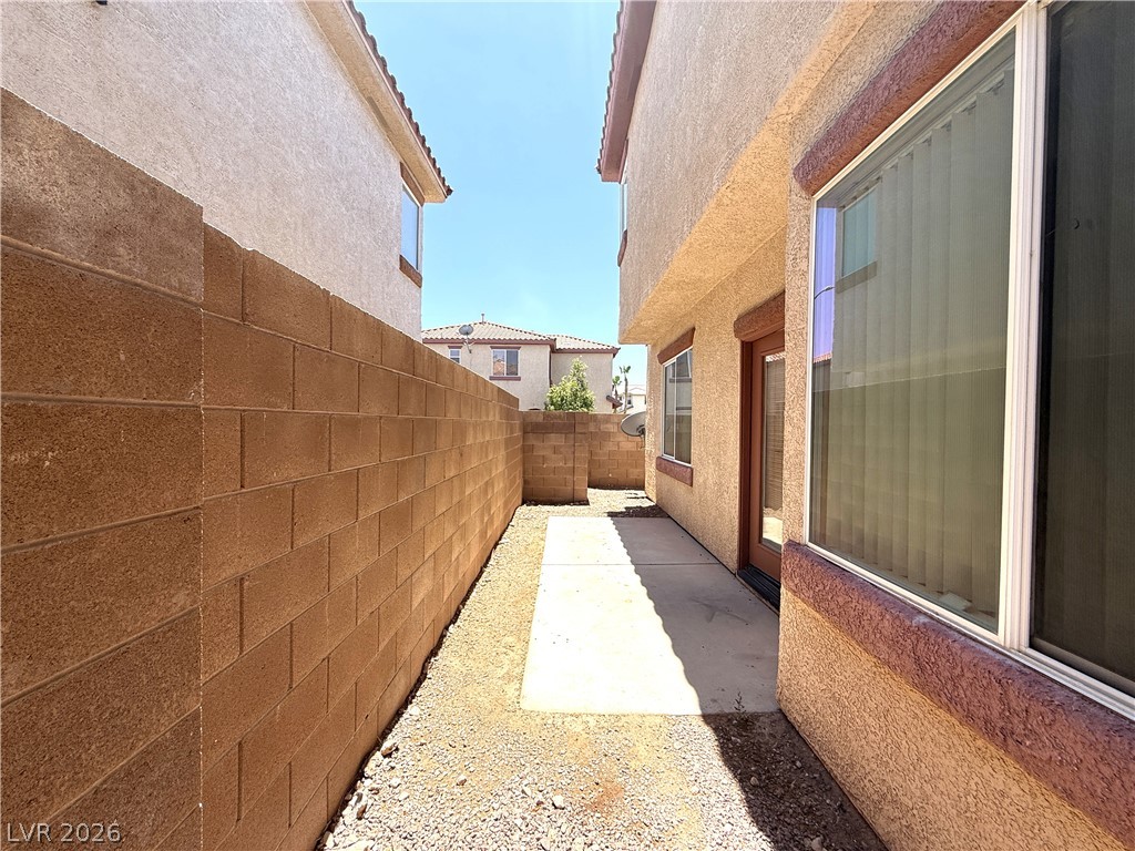 5942 Rampolla Drive Las Vegas, NV 89141 - Photo 26 of 27 A secluded side yard with a sturdy privacy wall, offering a private outdoor space.