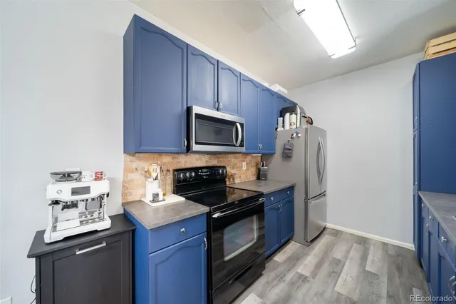 a kitchen with stainless steel appliances a stove a microwave a sink and cabinets