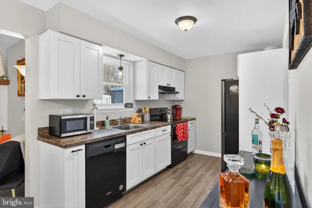 a kitchen with stainless steel appliances granite countertop a refrigerator sink and white cabinets