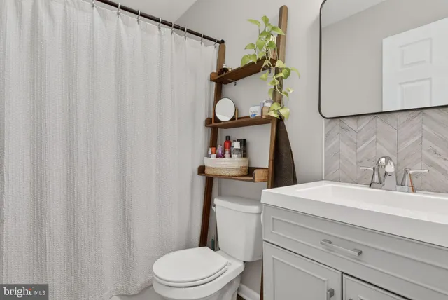 a bathroom with a sink a toilet and shower curtain