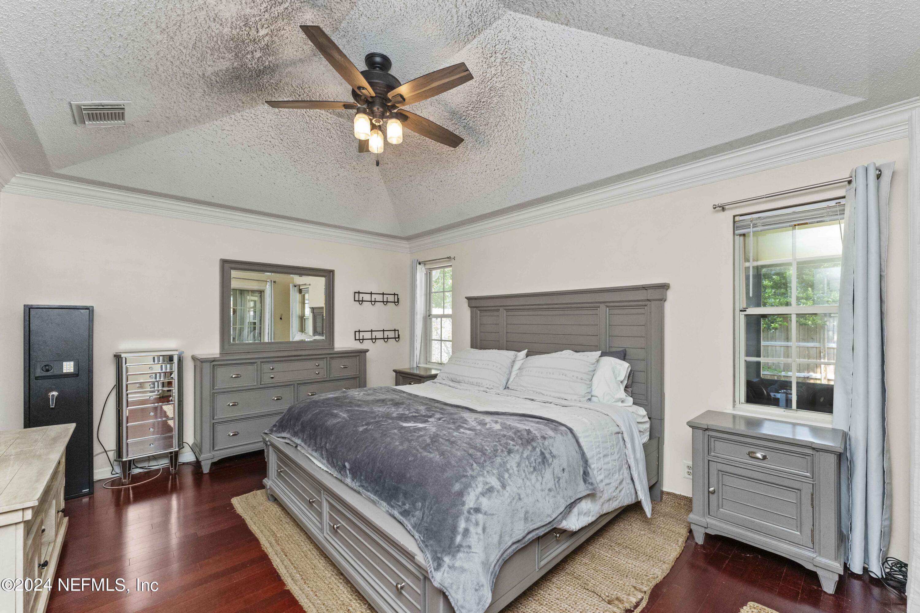8808 Goodbys Trace Drive Jacksonville, FL 32217 - Photo 12 of 25 a bedroom with a large bed and a chandelier