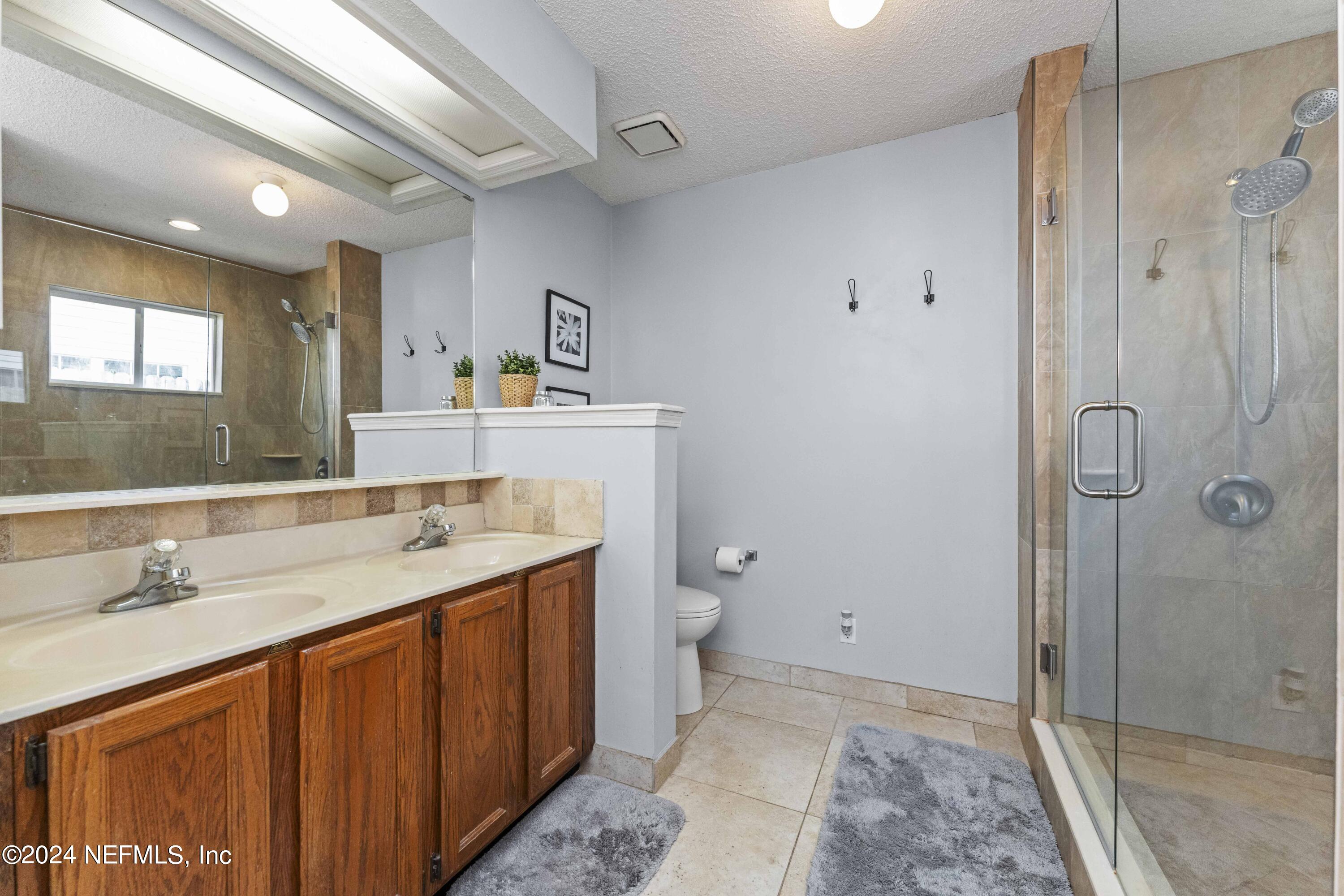 8808 Goodbys Trace Drive Jacksonville, FL 32217 - Photo 14 of 25 a bathroom with a granite countertop sink a toilet and shower