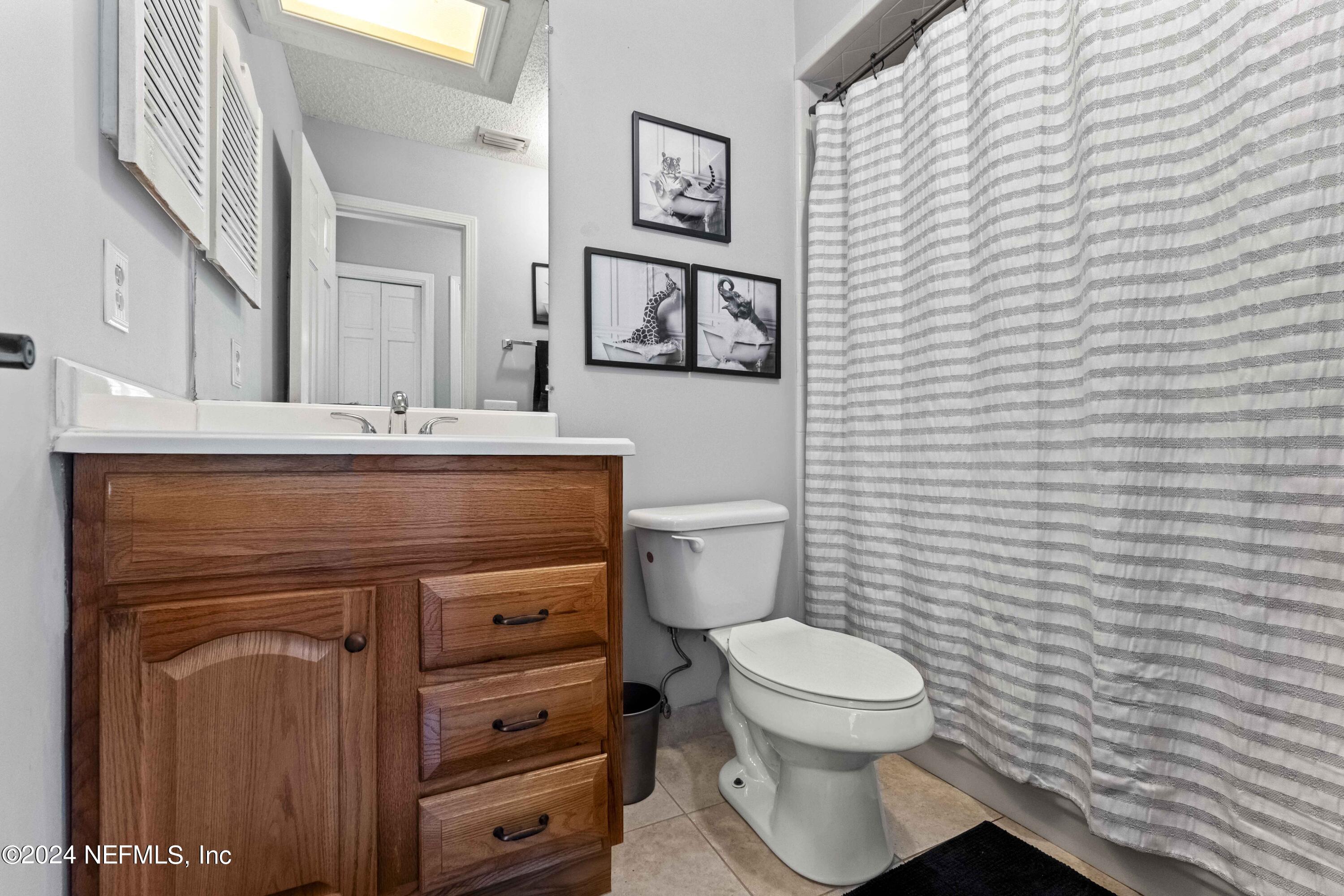 8808 Goodbys Trace Drive Jacksonville, FL 32217 - Photo 17 of 25 a bathroom with a toilet a sink and mirror